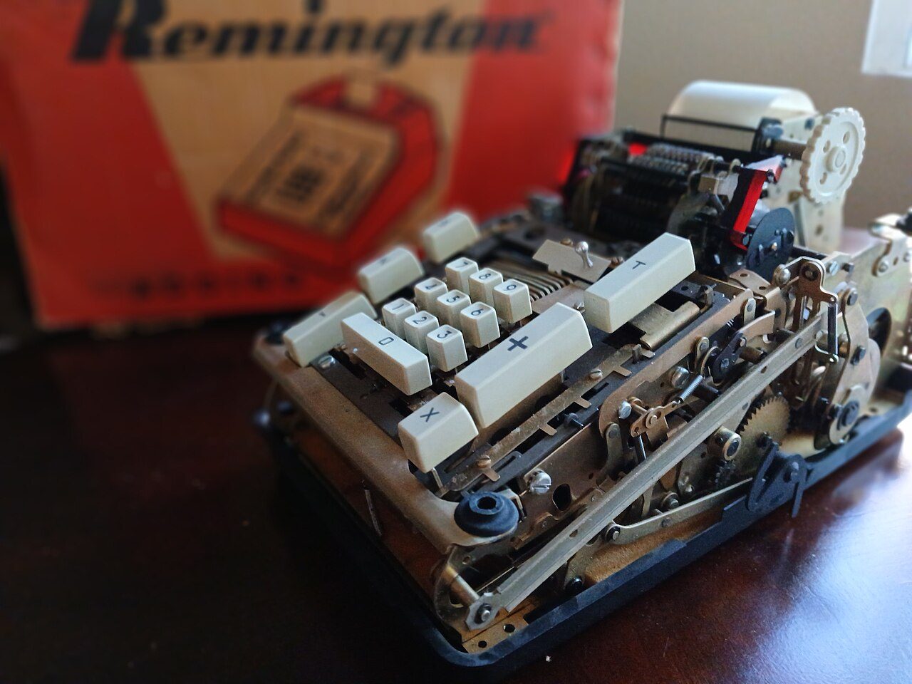 A Remington adding machine with exposed gears and a paper roll