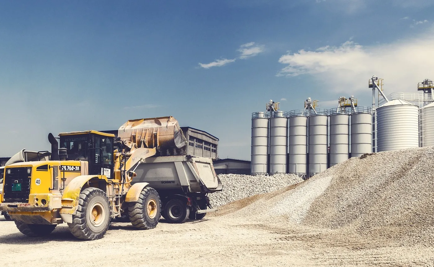 A wheel loader dumping beside grain silos
