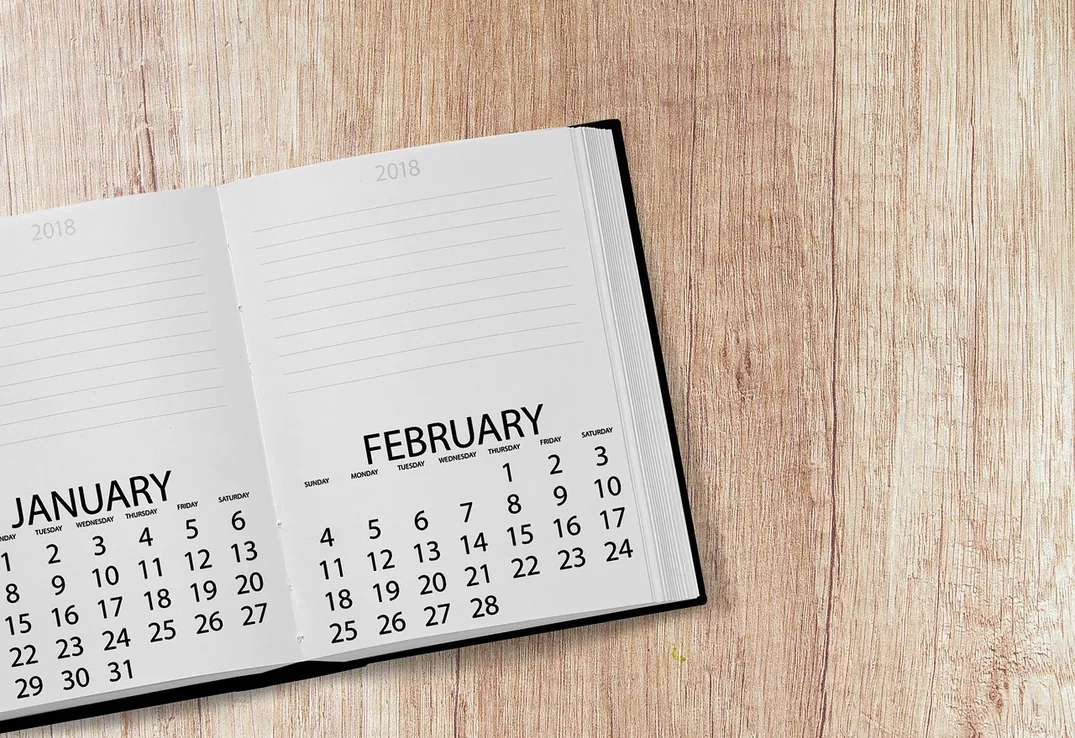 An open desk calendar shows January and February, because the four lines have to be settled before that month closes.