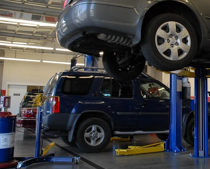 A vehicle raised on a lift inside a bay