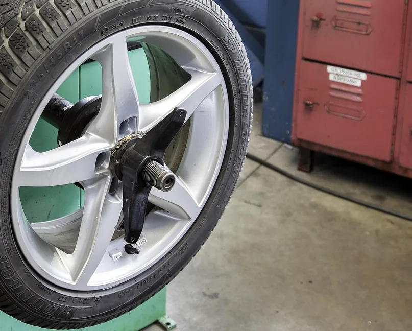 A tire and wheel standing in a shop