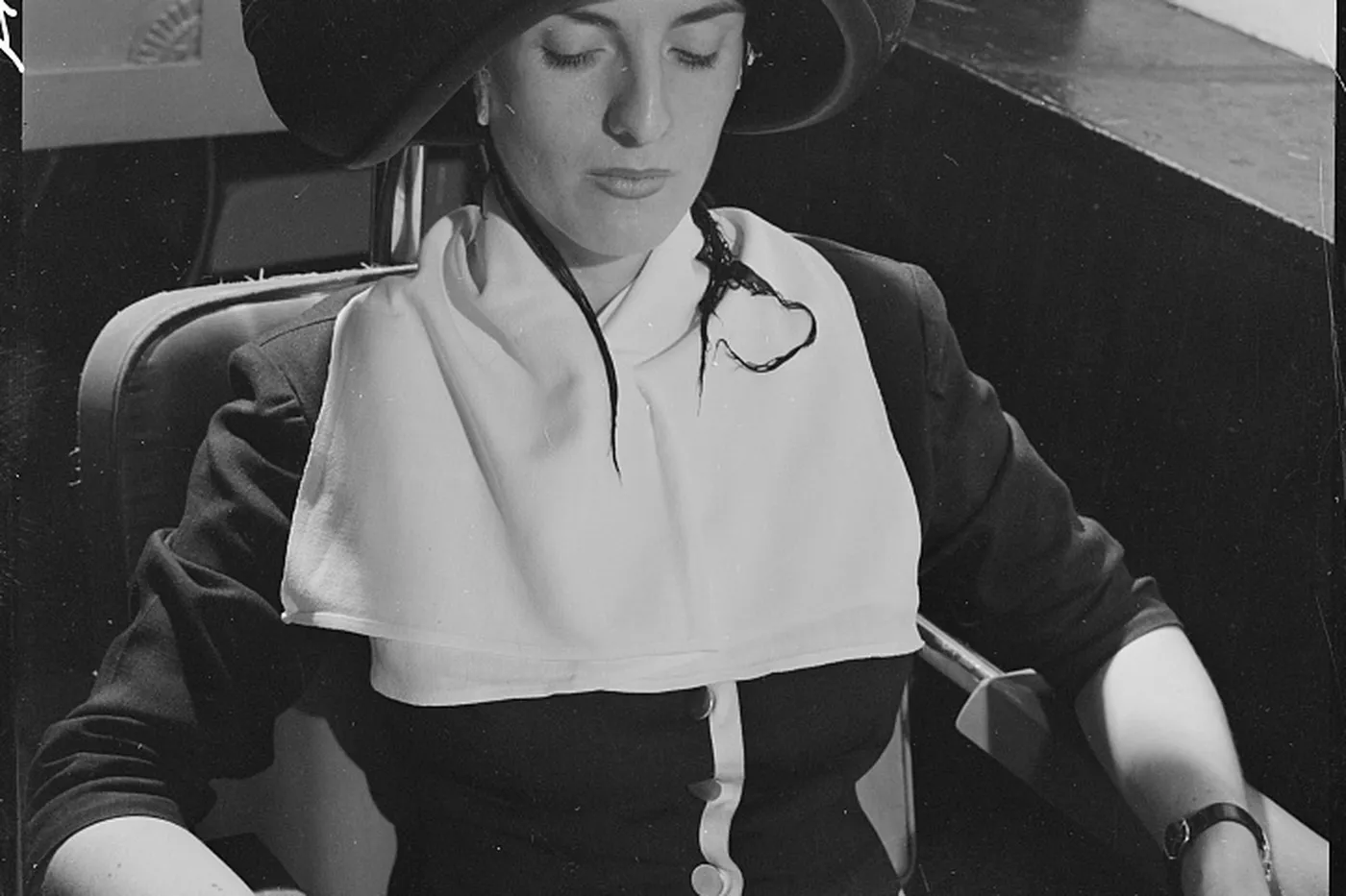 A guest seated under a hooded dryer, reading while the chair is in use.