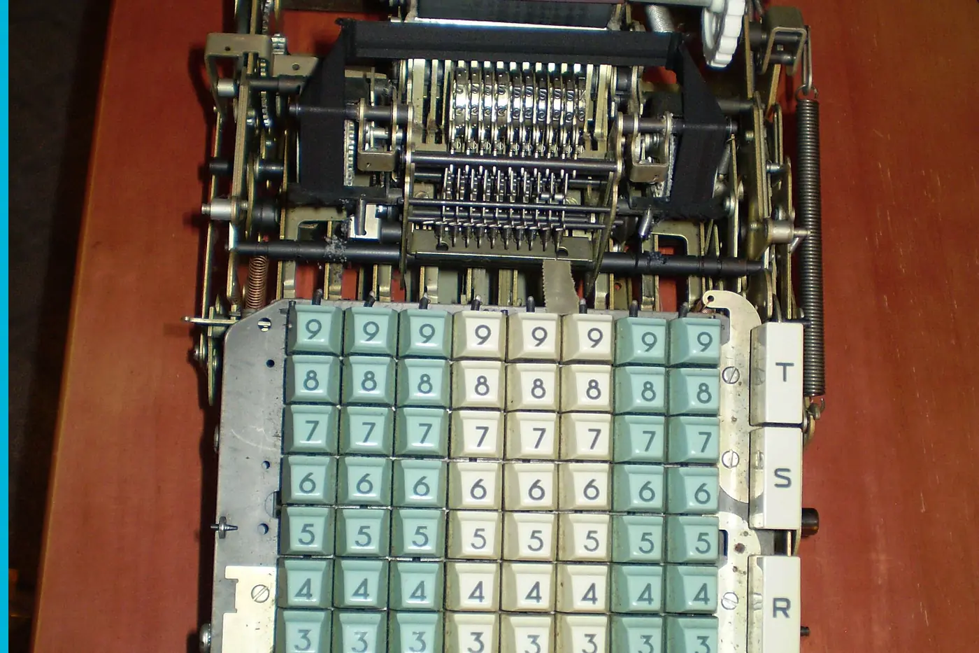 An adding machine with the cover off and a paper roll in place