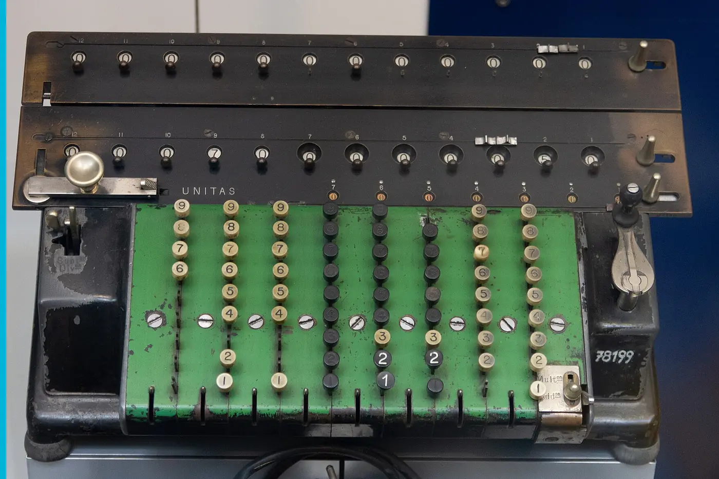 A mechanical calculator with green number keys