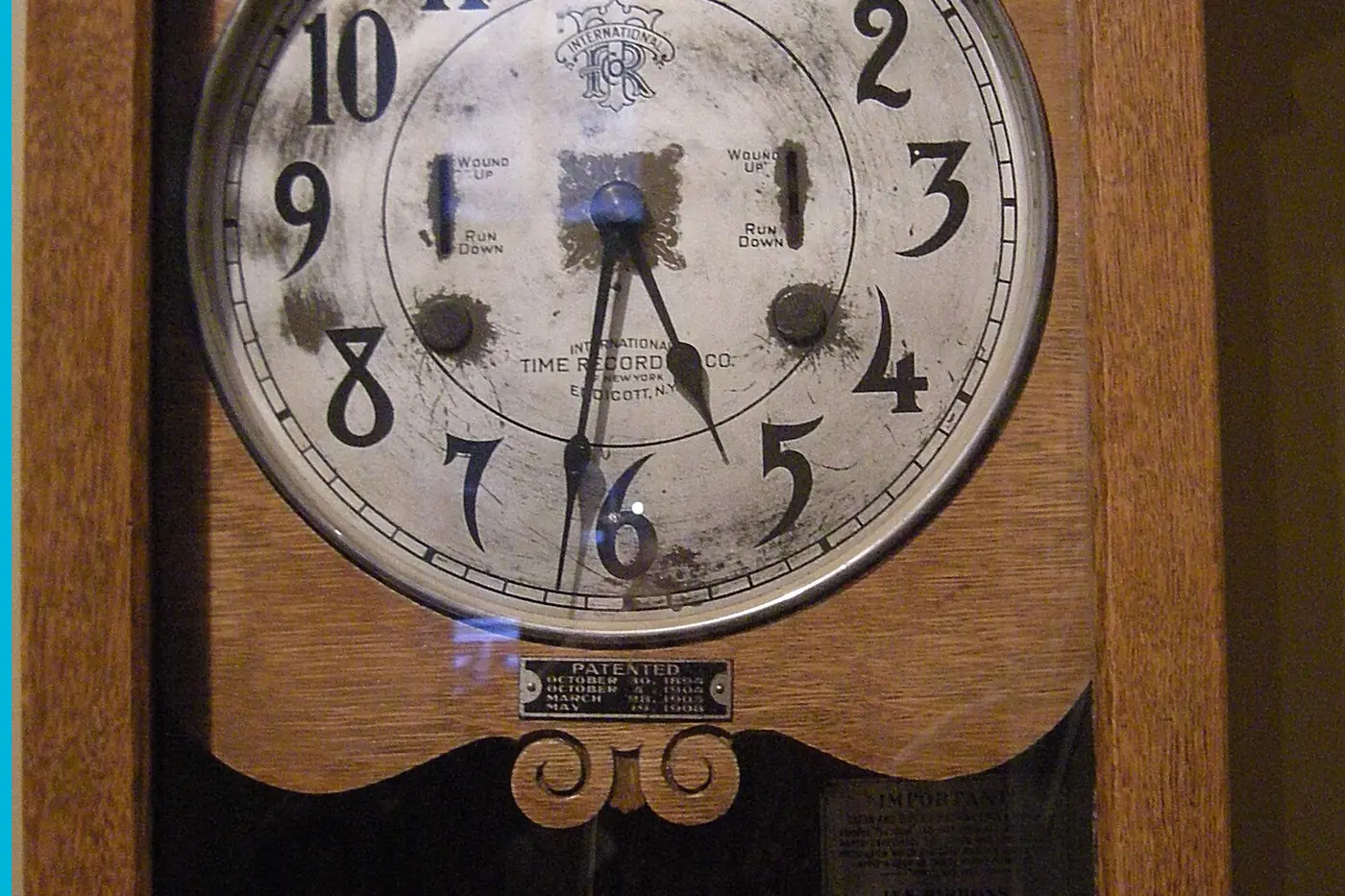A round time-clock face in a wooden case