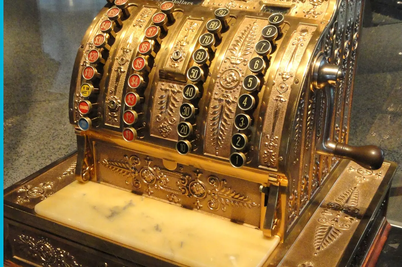 A brass cash register with the drawer and the keys