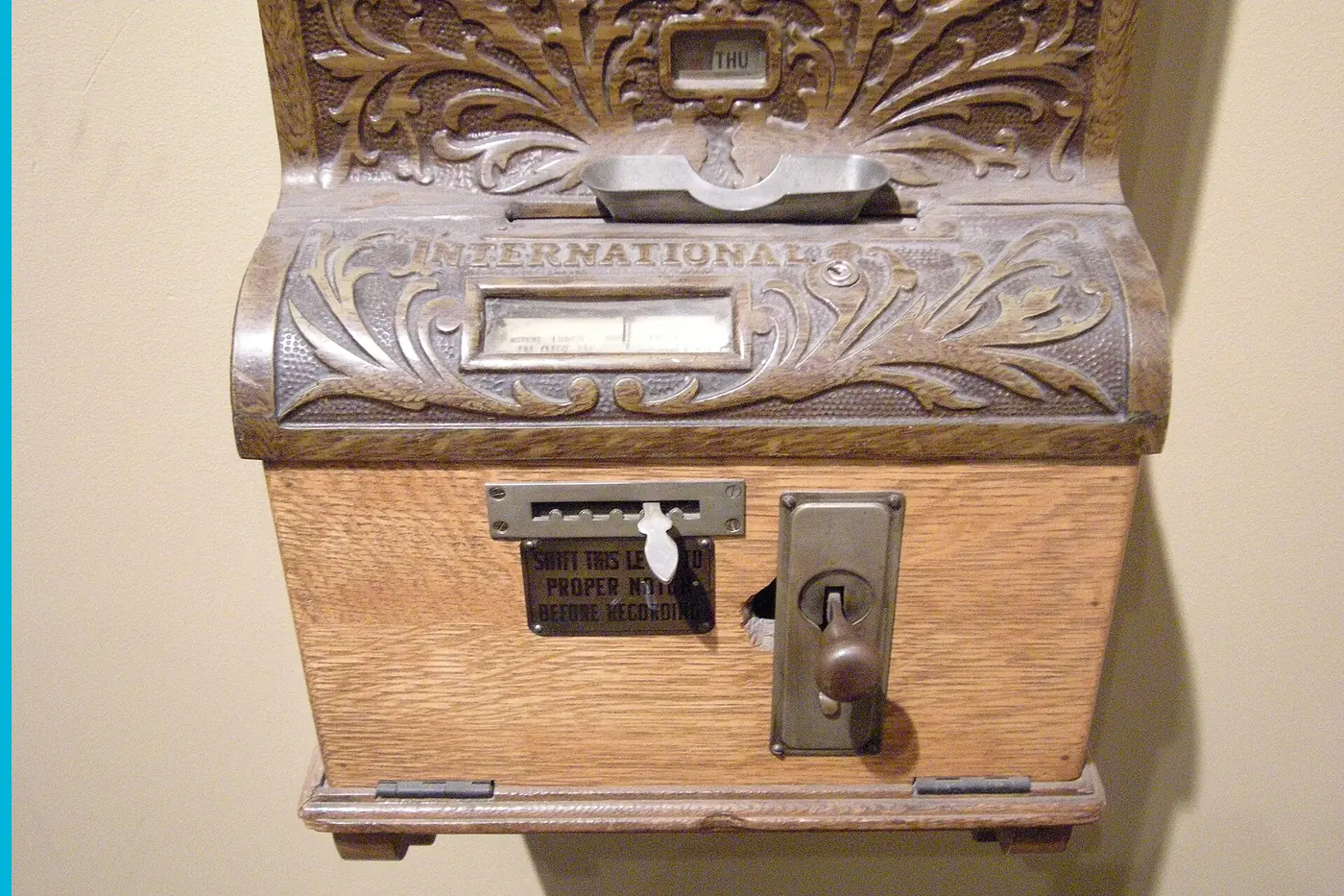 A wooden time clock, the punch slot under the brand plate