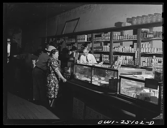 Two people stand at the counter inside a grocery store in San Augustine, Texas.