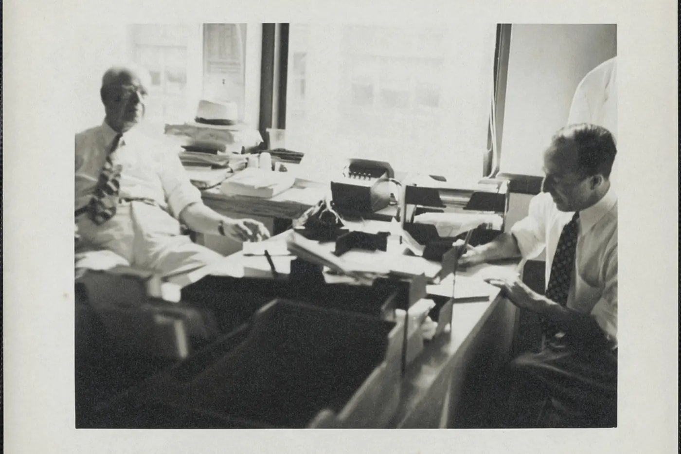 Two men reviewing papers together at a work table