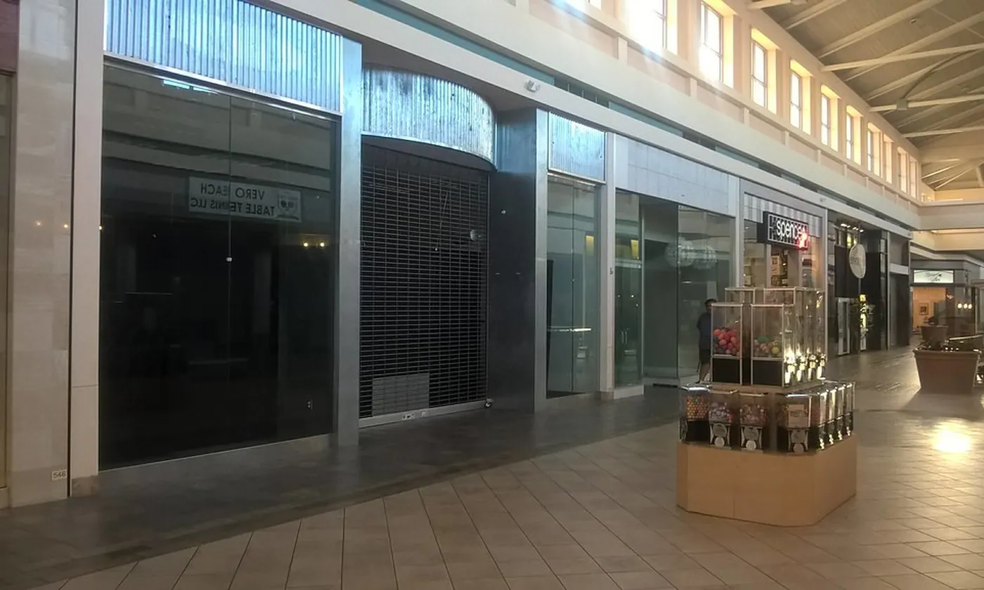 A row of empty shop units with the lights on