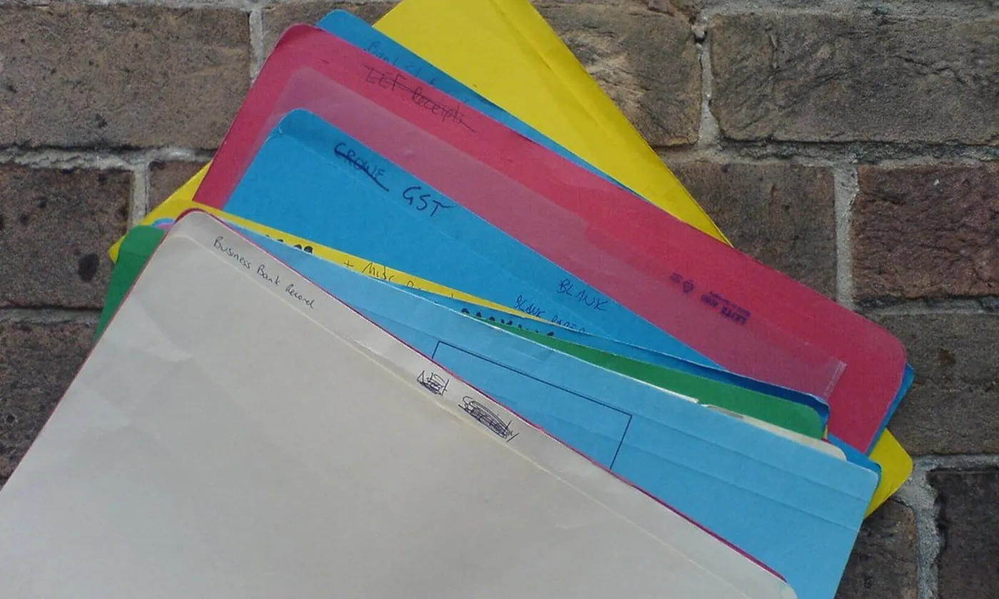 A fan of colored file folders on a brick ledge