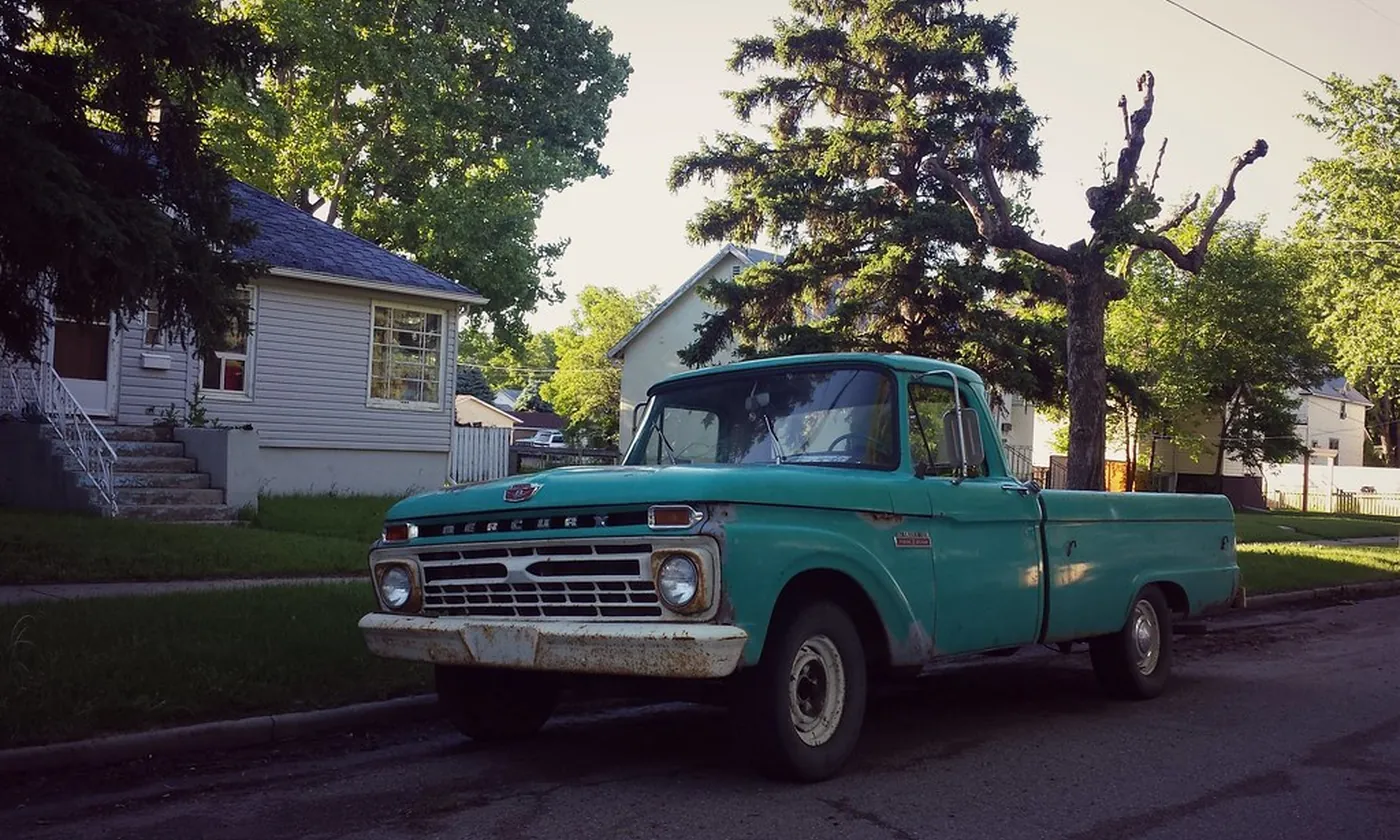 An old pickup truck parked in a yard