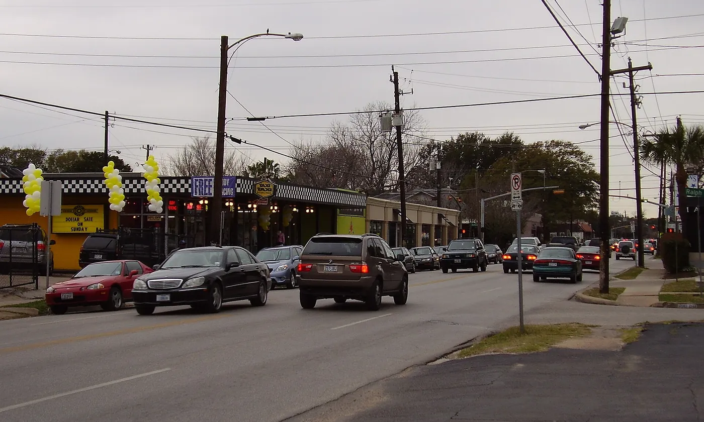 A row of shops and traffic on a grey day in the Montrose area of Houston