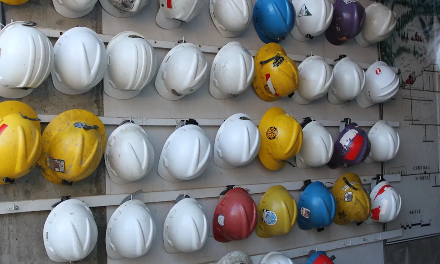Rows of hard hats hanging on a wall, ready for a crew