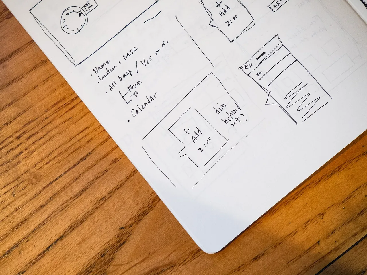 An open notebook with a sketched calendar and a pen