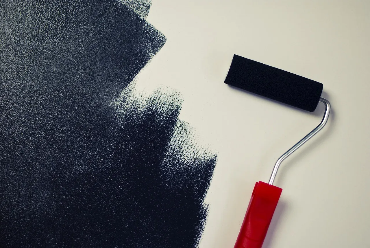 A paint roller beside a fresh coat
