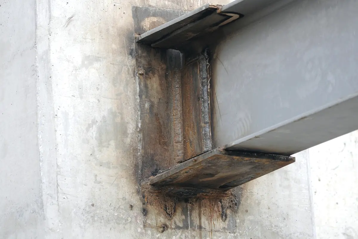 A steel beam bolted into a concrete wall