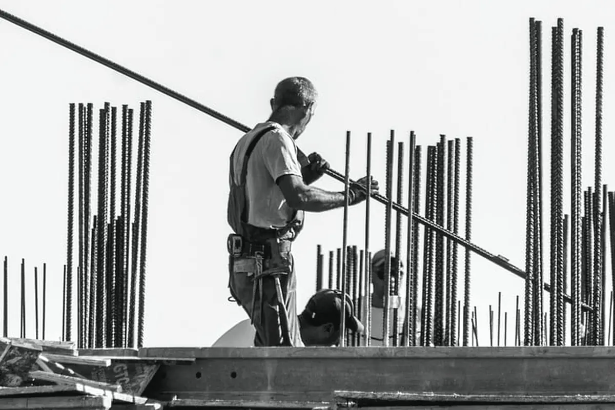 A worker setting vertical steel on a deck