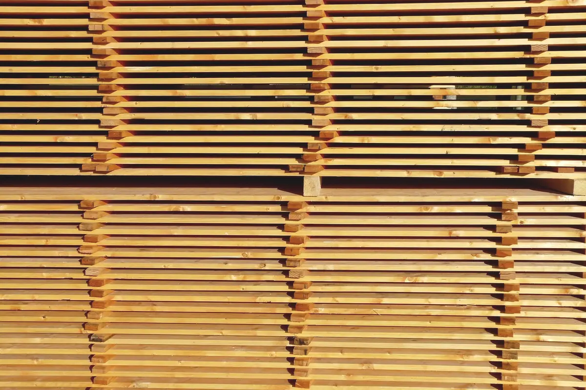 Stacks of pale lumber filling a warehouse bay