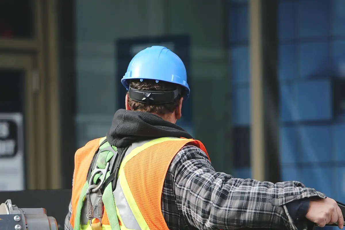 A worker in an orange vest and a blue hard hat