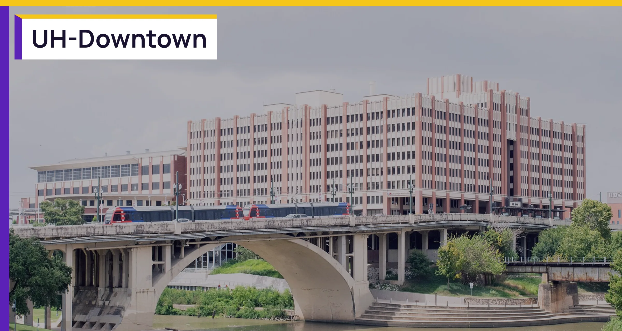 The University of Houston Downtown campus beside the bayou, with the words UH-Downtown