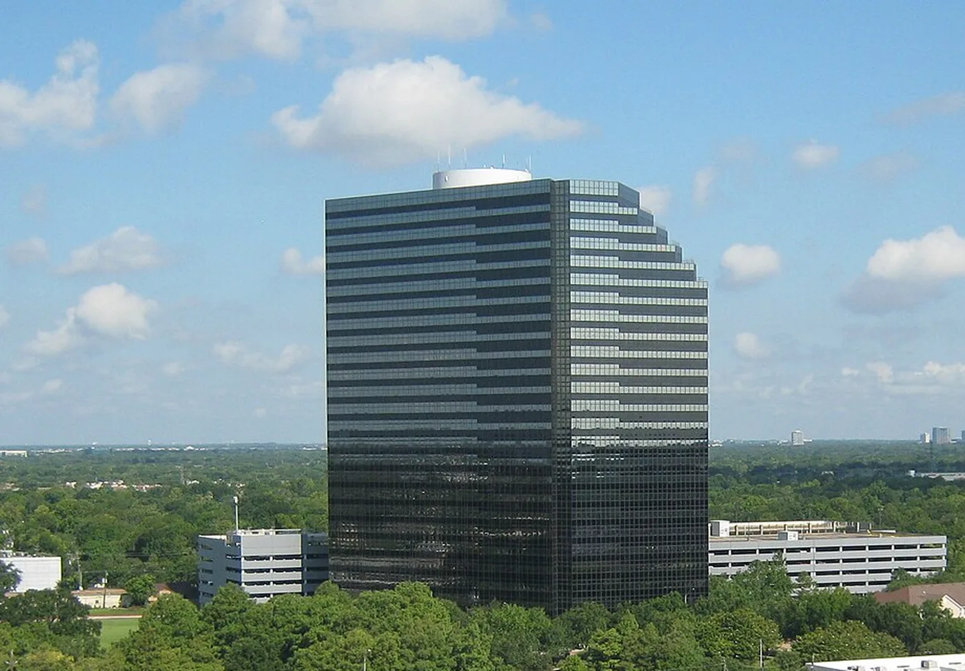Dark glass tower above the trees