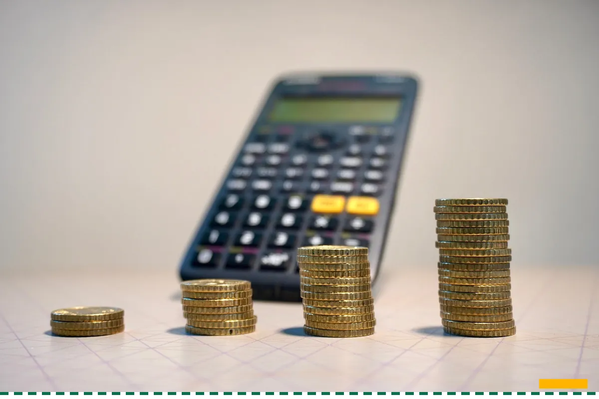A calculator standing behind stacks of coins of different heights