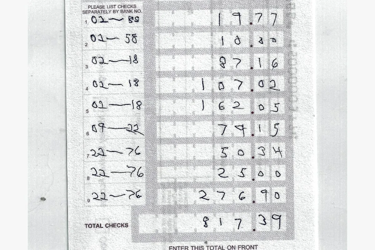 The back of a deposit slip, the checks listed and the total written once.