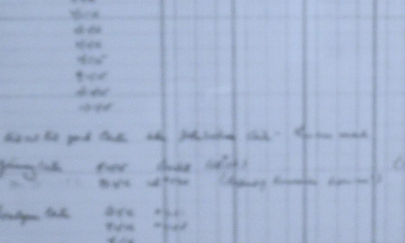 A ruled ledger page behind glass