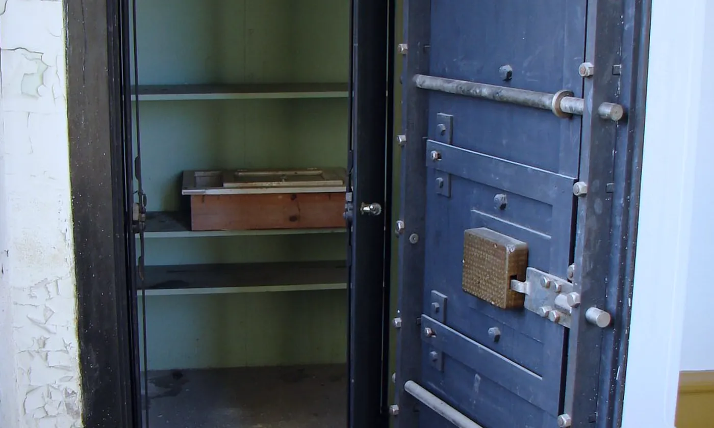 A vault door open onto empty shelves