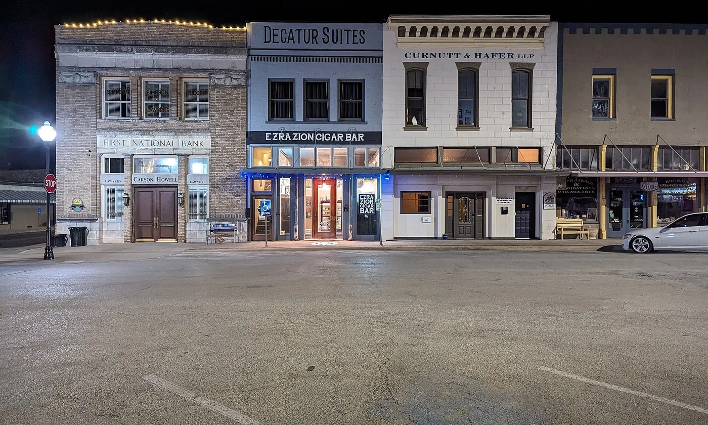 A row of shops on the courthouse square in Decatur, Texas, lit up in the evening