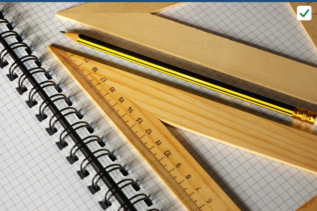 A spiral notebook with grid paper, wooden rulers and a pencil
