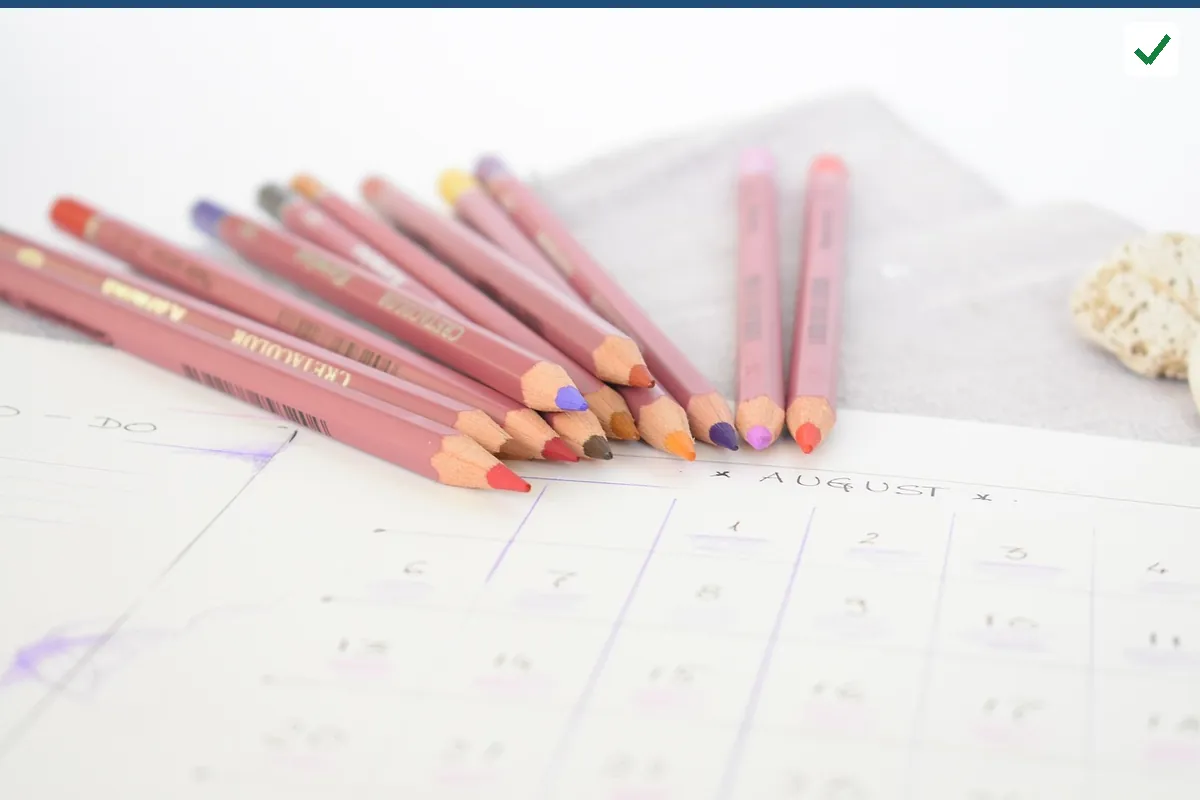 Colored pencils resting on a printed calendar grid