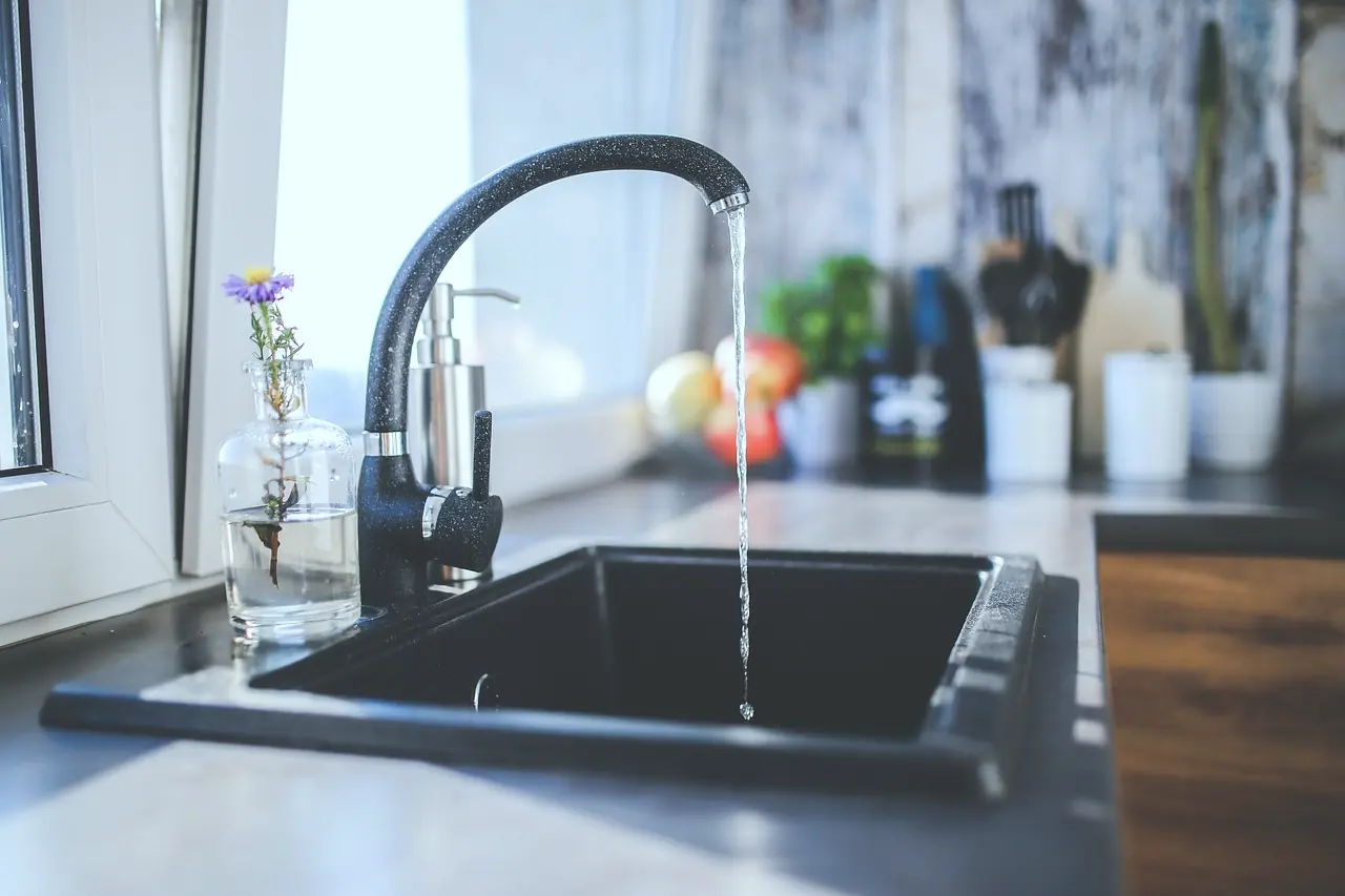 A black kitchen faucet over a sink
