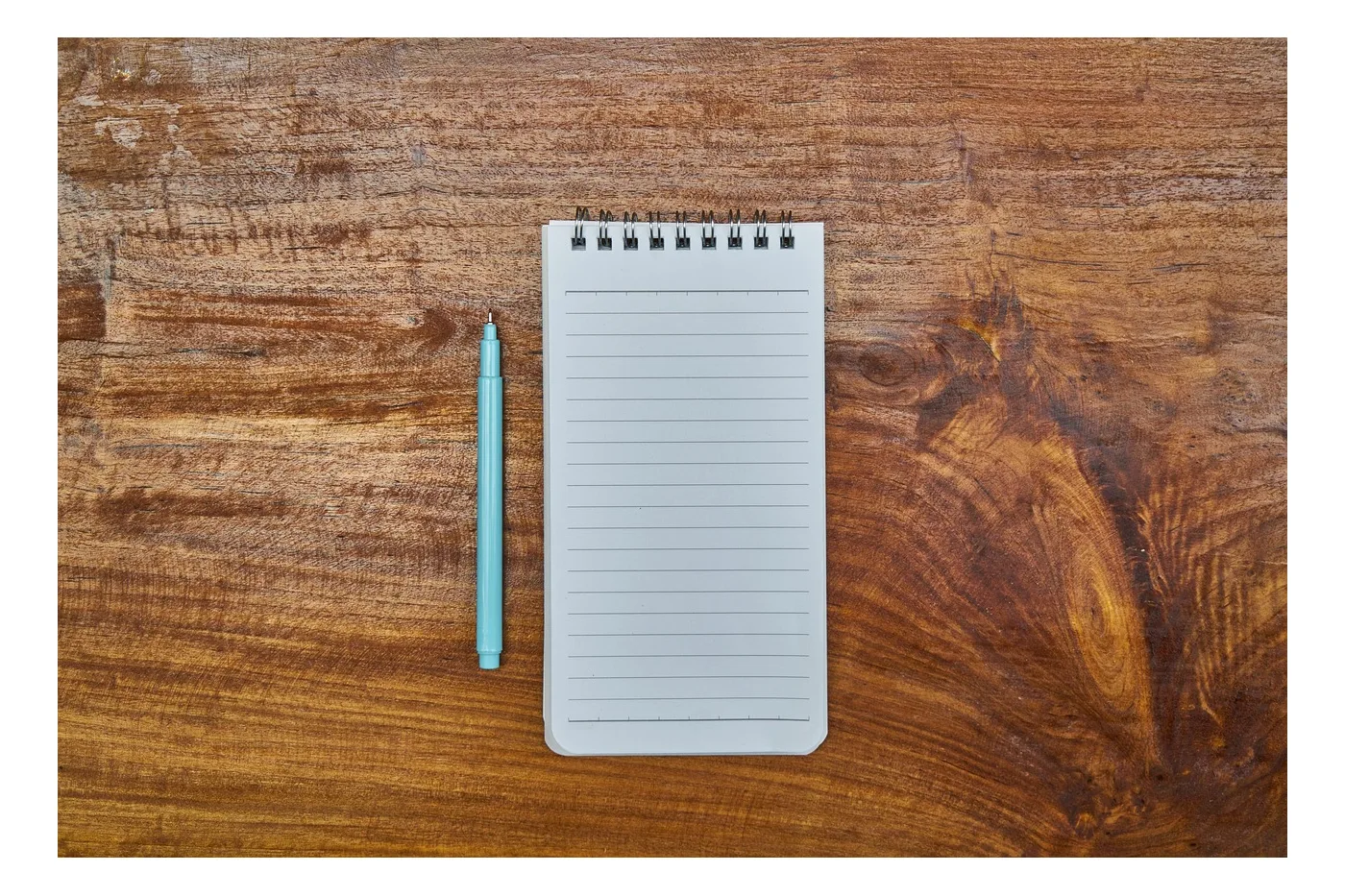 A blank notepad and a pen, the job word not written yet