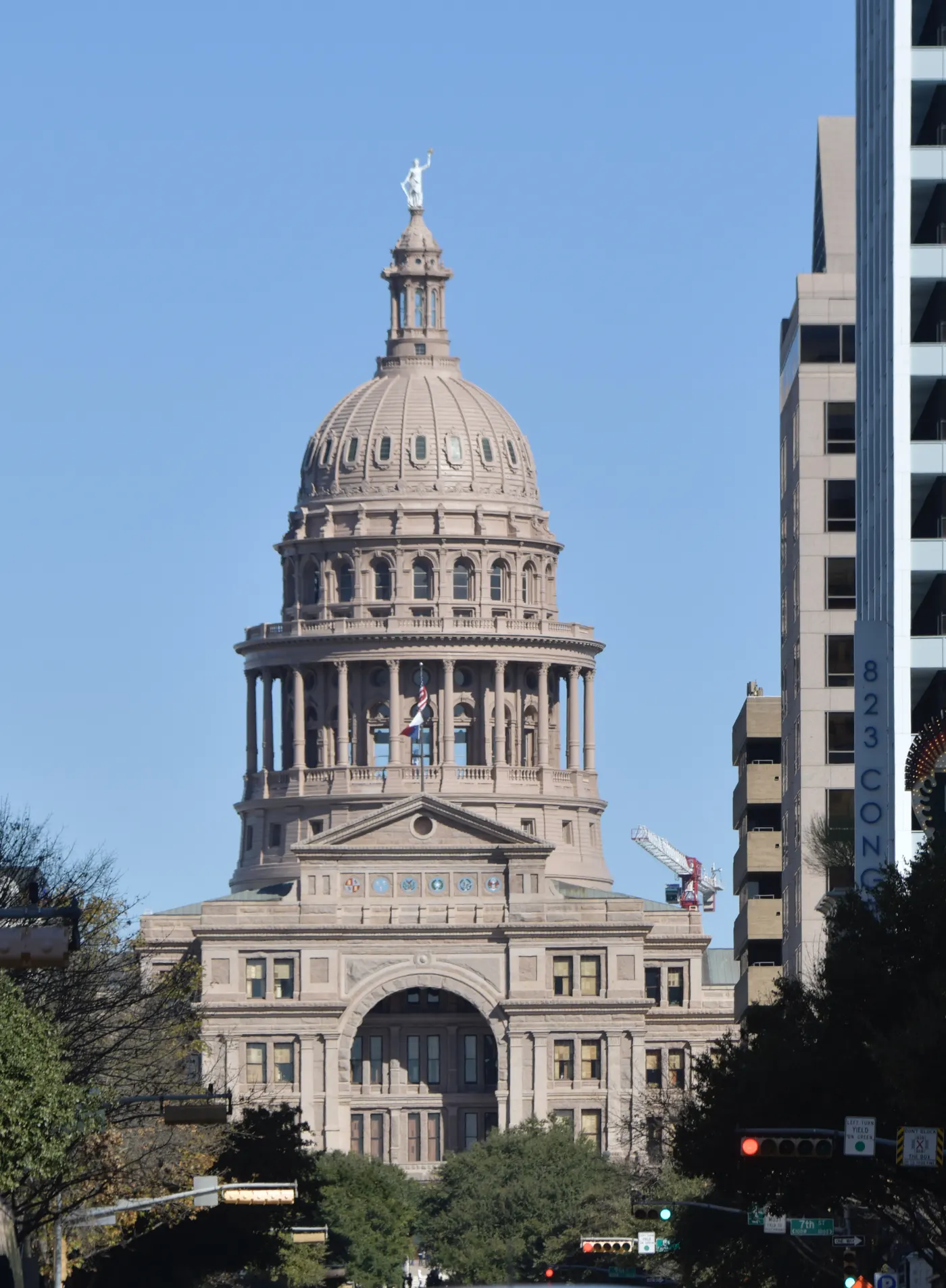 The Texas State Capitol, pink granite dome and the state flag.