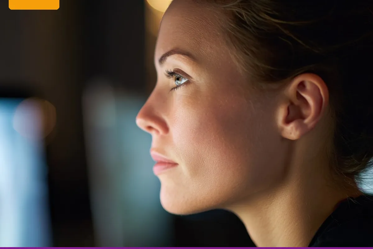 A person in profile looking at a screen that is out of focus