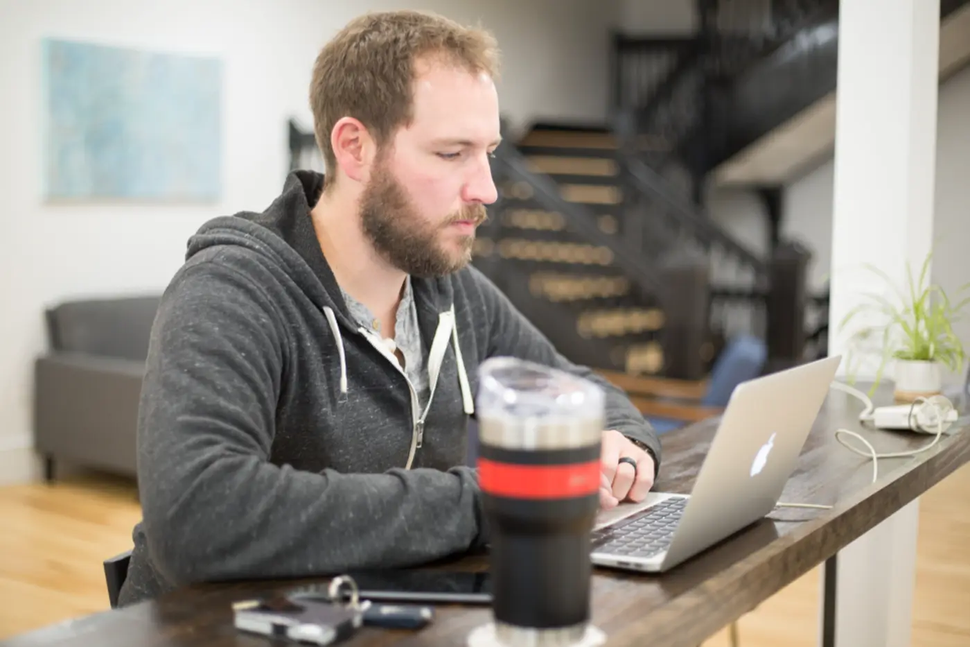 A person at a laptop, face turned toward the screen.