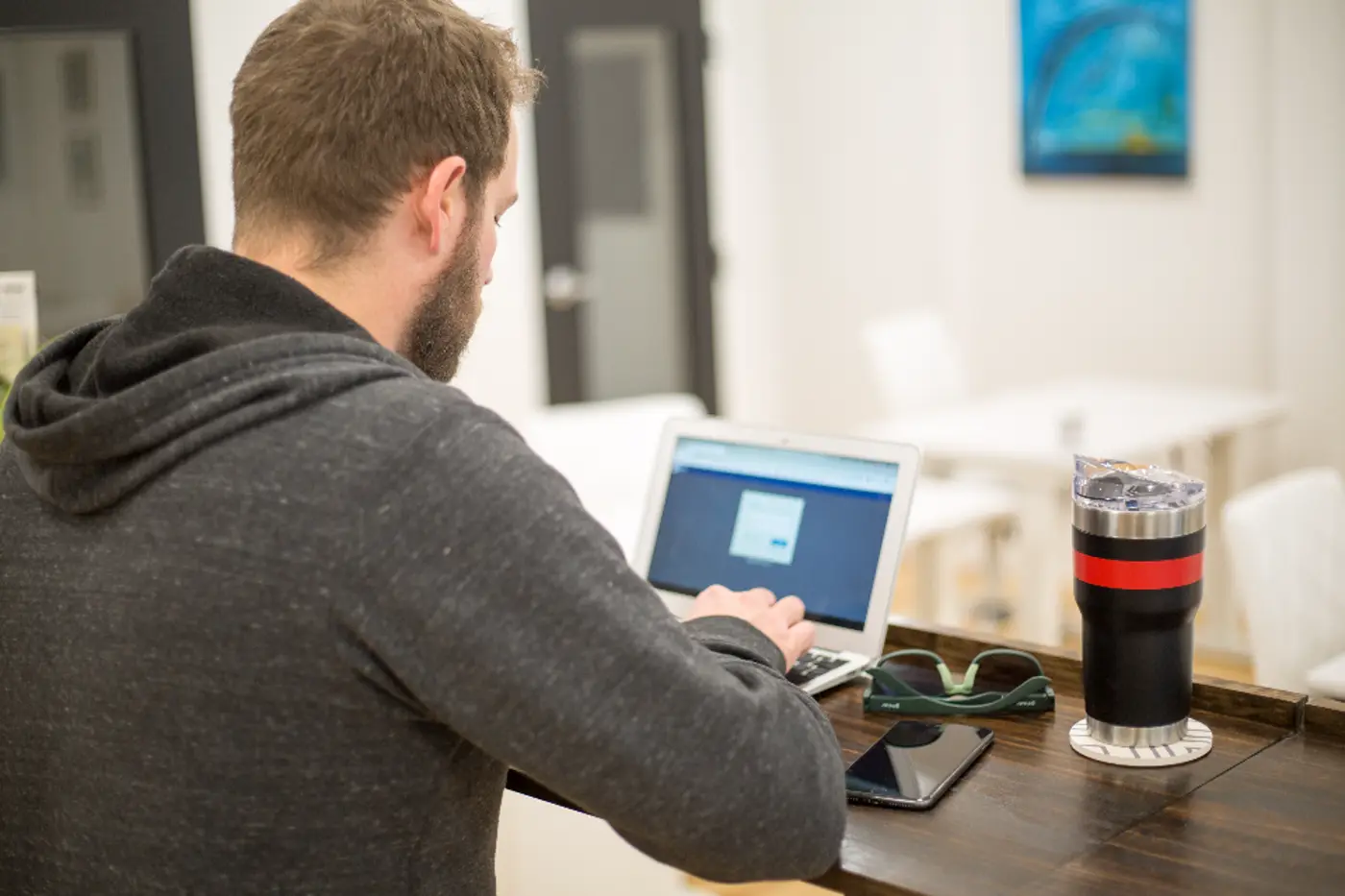 A person at a laptop whose screen shows a small dialog.