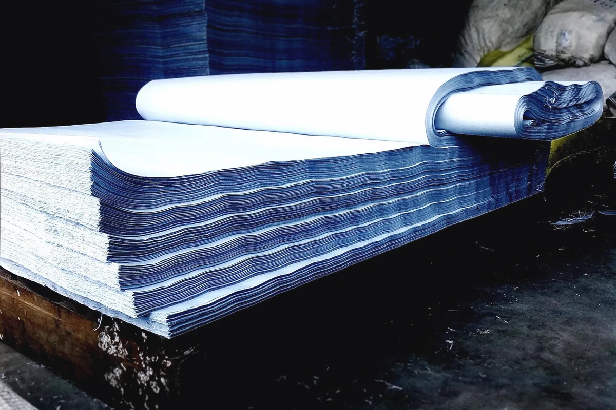 A tall stack of blank paper, with no printing on the sheets.