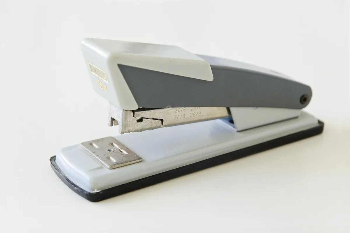 A grey stapler on a light surface, with no brand name readable.