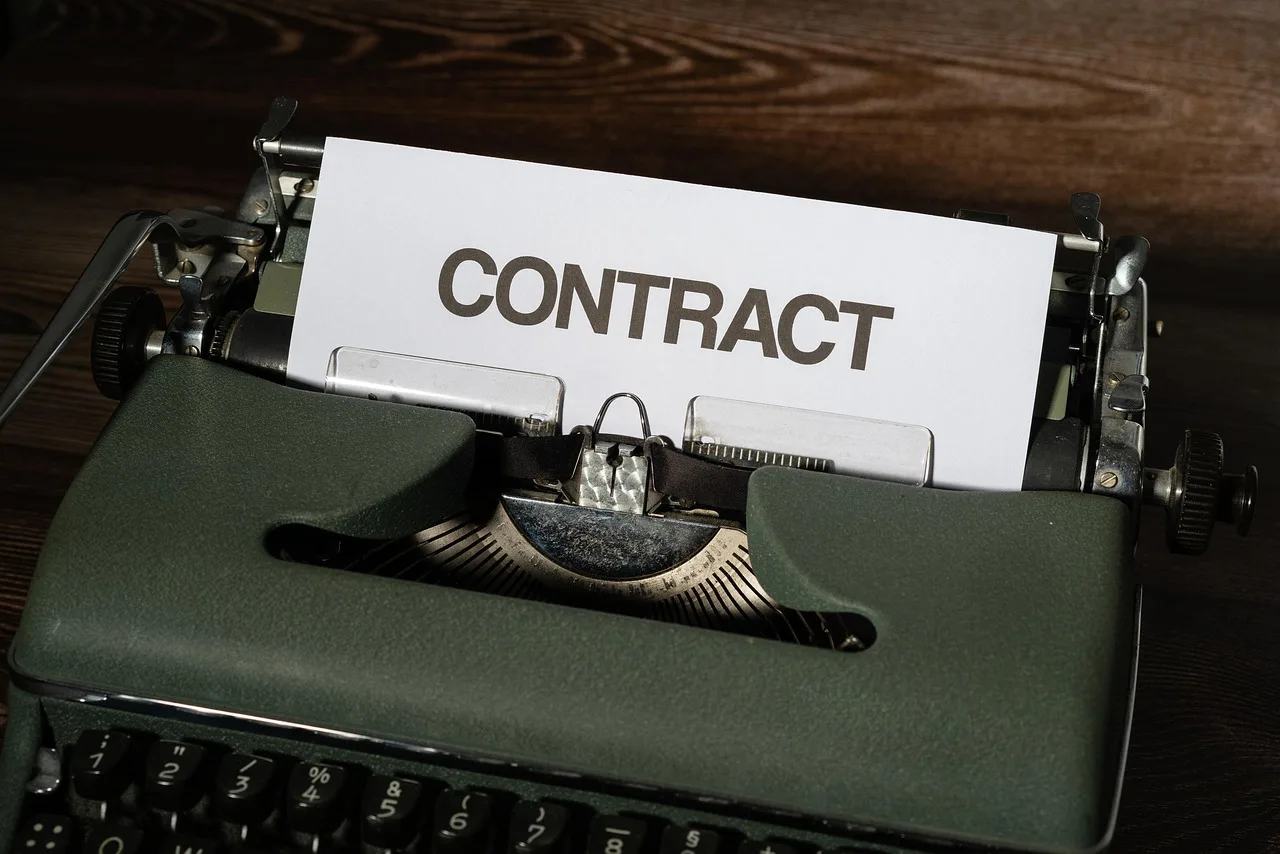 A typed contract on a desk, the page a release still has to name.