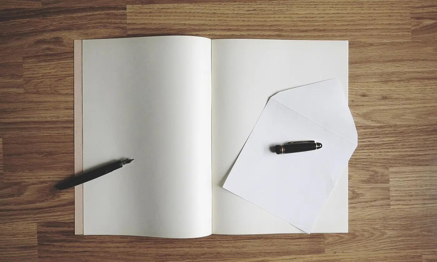 A blank page and an envelope on a table, the second paper that has not been filled in.