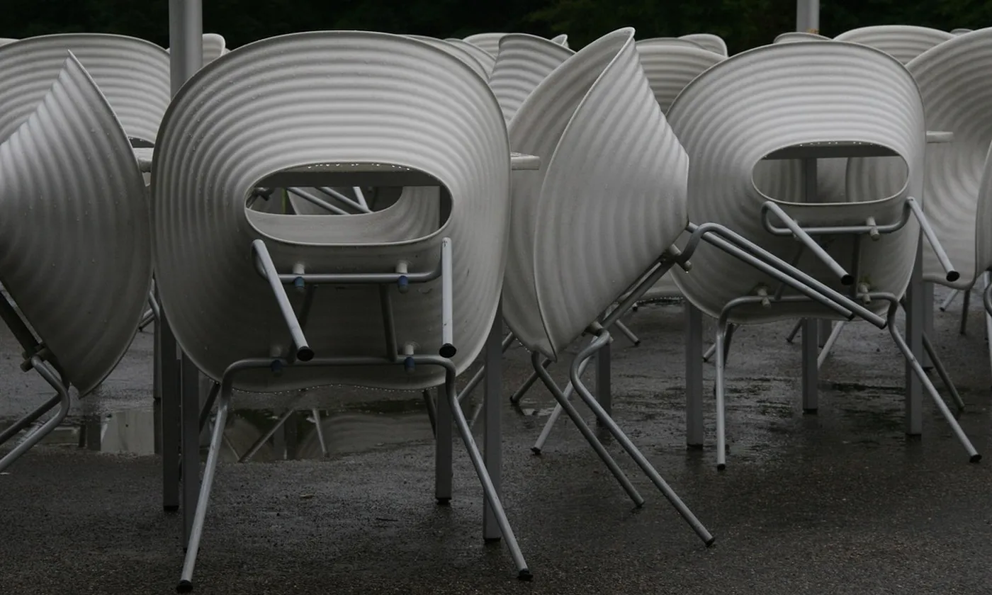 Cafe chairs turned up on their tables after the room has closed.
