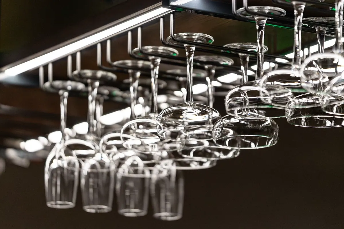 Wine glasses hanging over an empty bar, no labels and no guests.