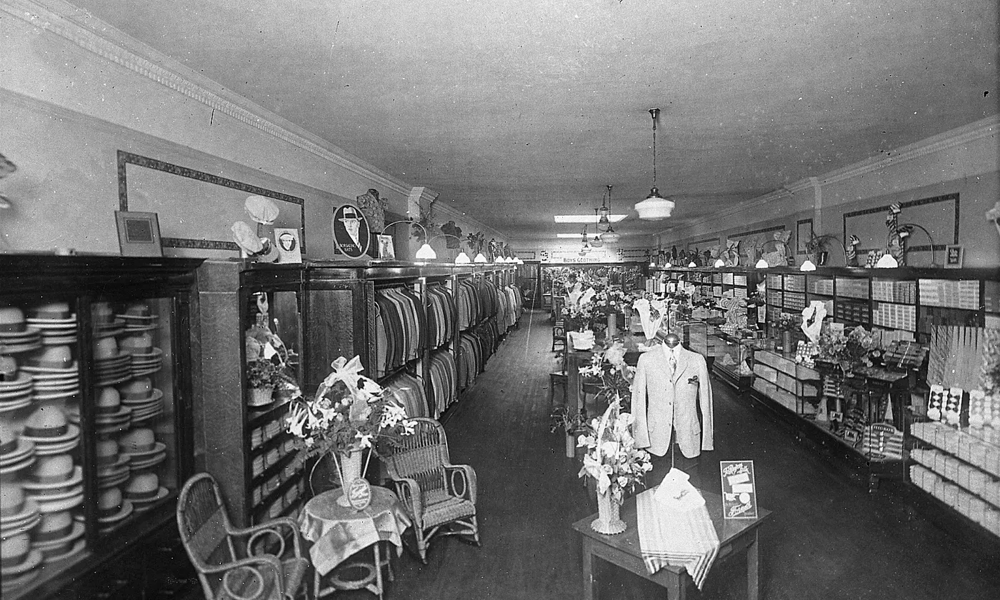 A long clothing shop aisle, with cases of goods on both sides.