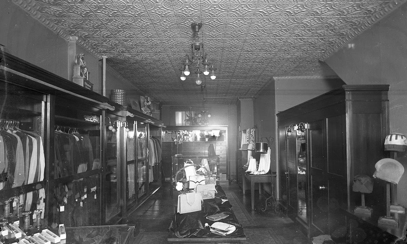 A shop interior with clothing cases along both walls and a table of goods in the middle.