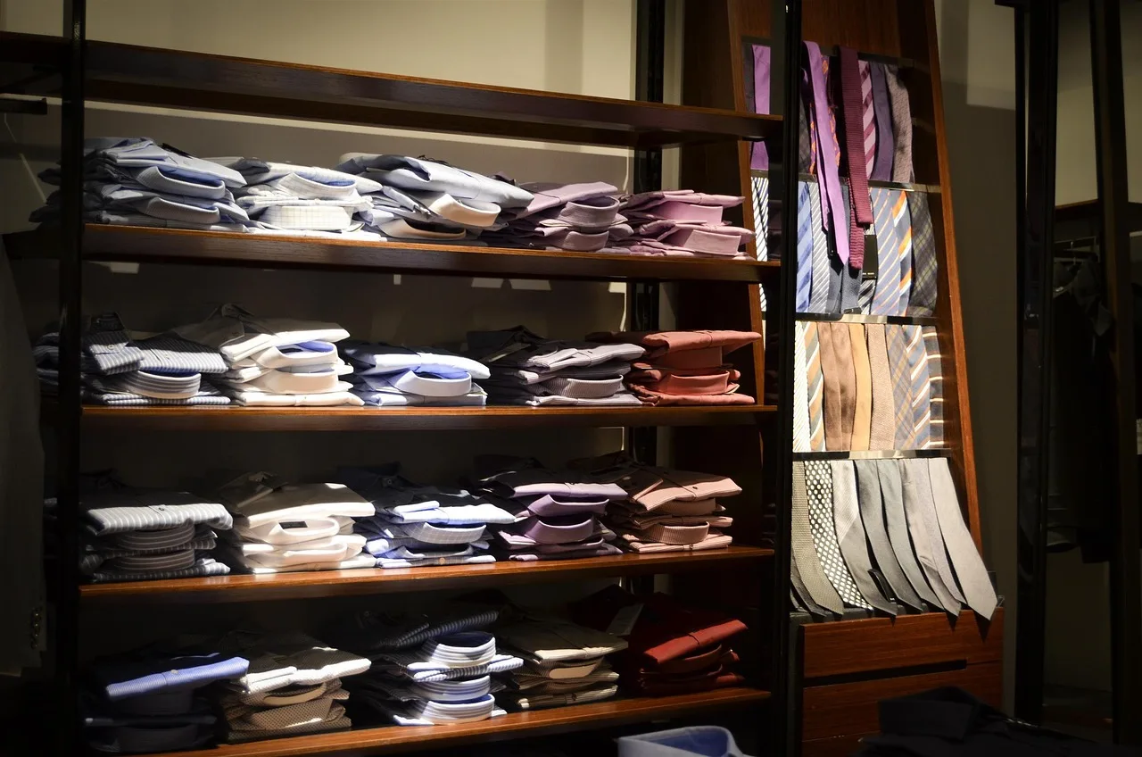 Folded shirts on wooden shop shelves, merchandise waiting on a count.
