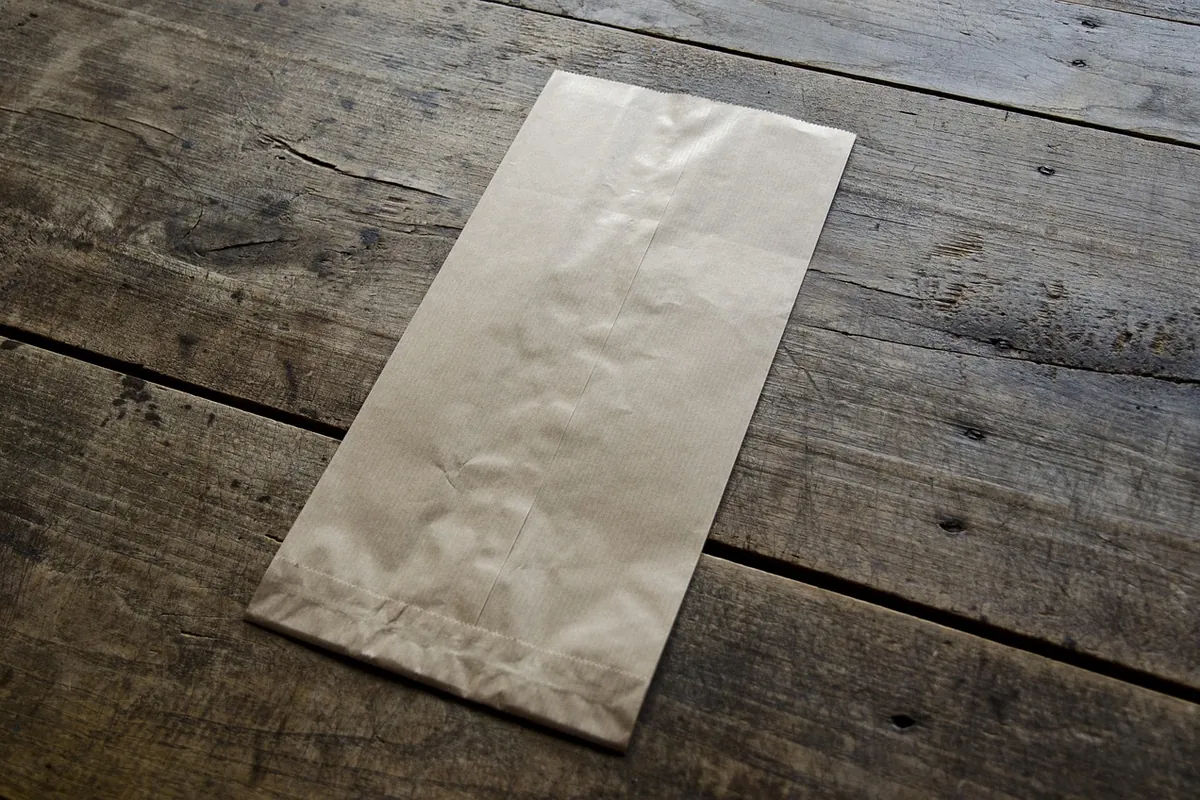 A plain paper bag on a wooden table