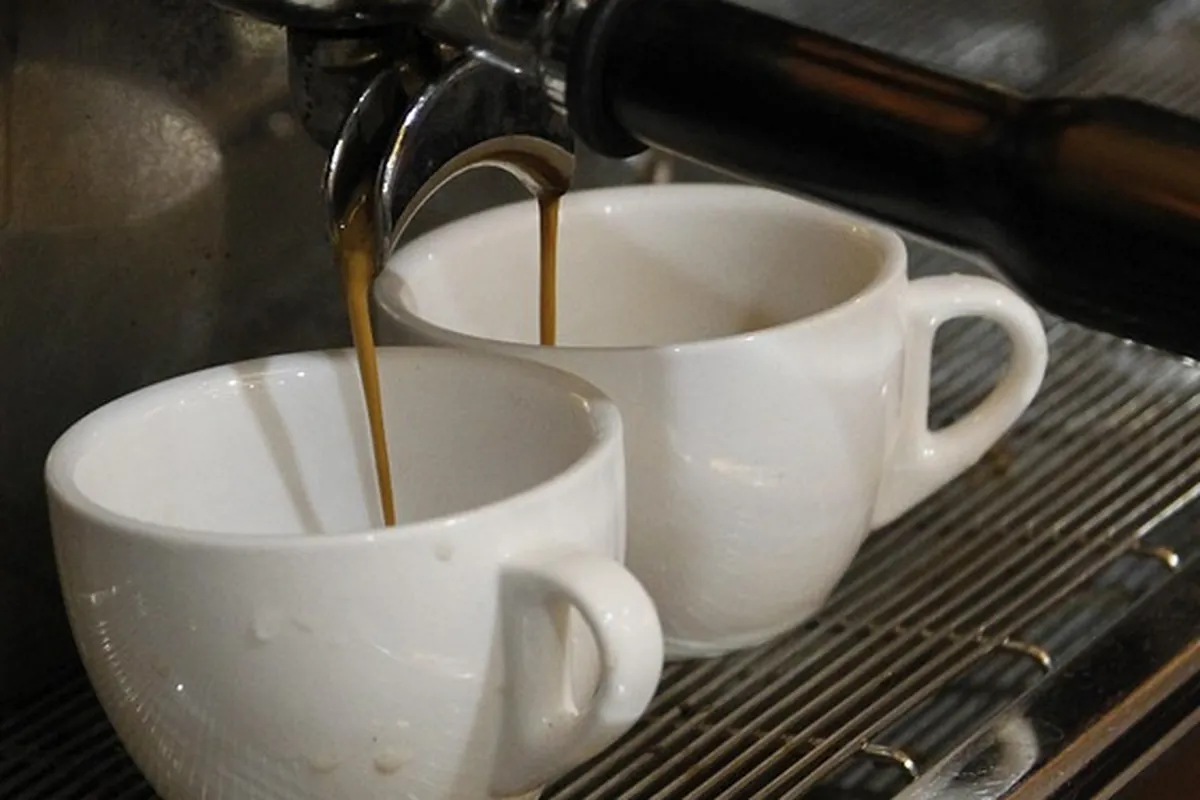 Espresso pouring into two white cups